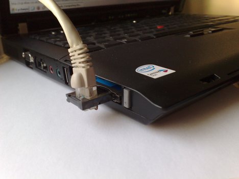 Modem w laptopie w postaci karty PC-Card z gniazdem typu XJACK i wetkniętym do niego kablem telefonicznym